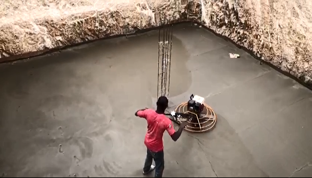 Jake Construction crew power-trowel finishing the floor of a 35,000-gallon cistern